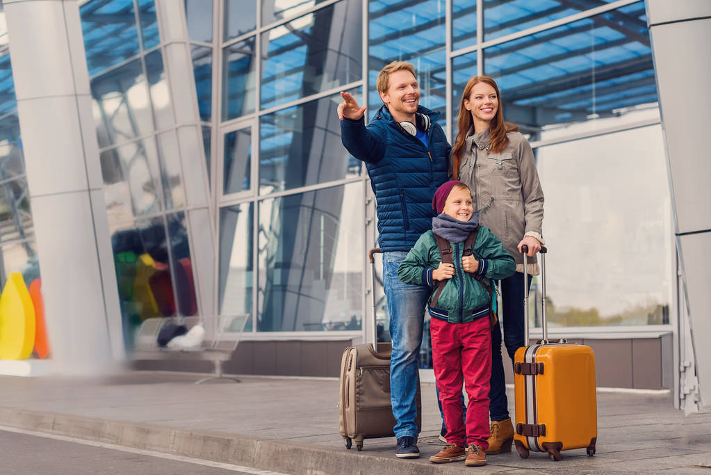 Χαμογελαστά οικογένεια με παιδί στο αεροδρόμιο - Φωτογραφία, εικόνα
