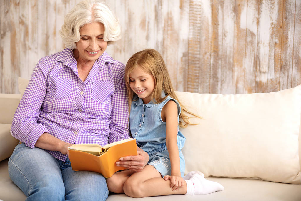 Tipo avó e menina entreter com livro em casa
 - Foto, Imagem