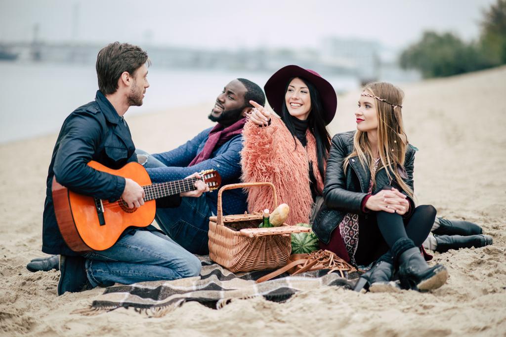 Jovens amigos felizes com guitarra no piquenique
 - Foto, Imagem
