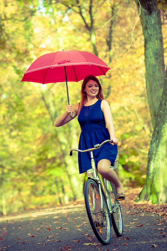 Hermosa chica ciclismo con paraguas
. - Foto, Imagen