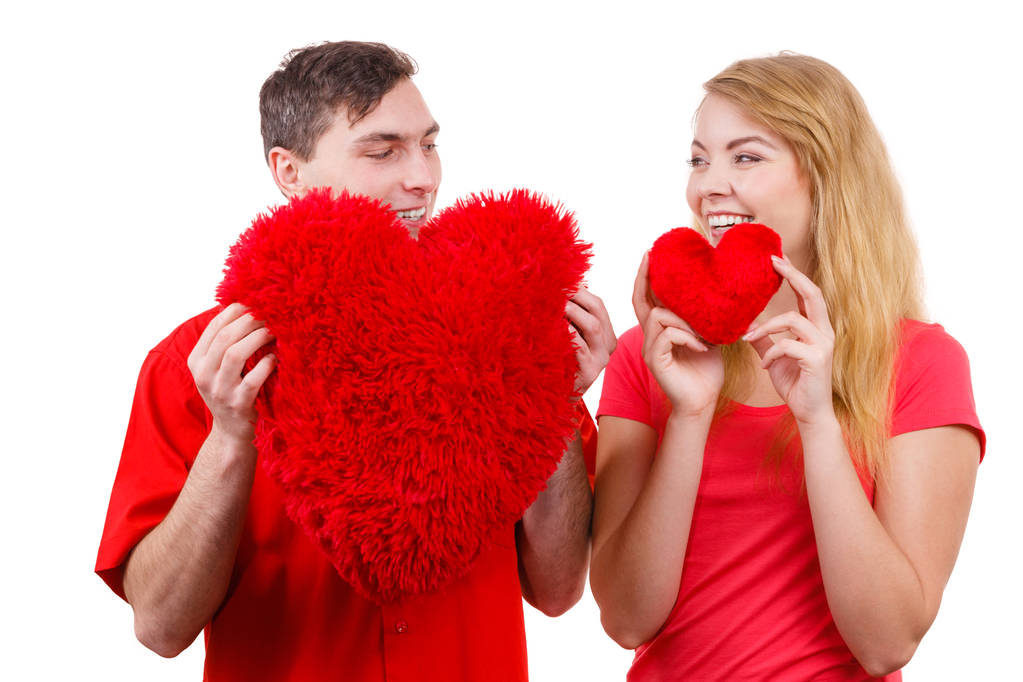 Couple holds red heart shaped pillows love symbol  - Photo, Image