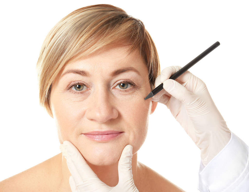 Chirurg ręce rysunku znaki na twarz kobiety do pracy z tworzywa sztucznego - Zdjęcie, obraz