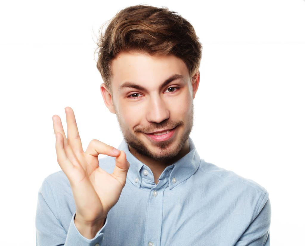 gelukkig glimlachende man tonen duim omhoog hand teken op witte achtergrond - Foto, afbeelding