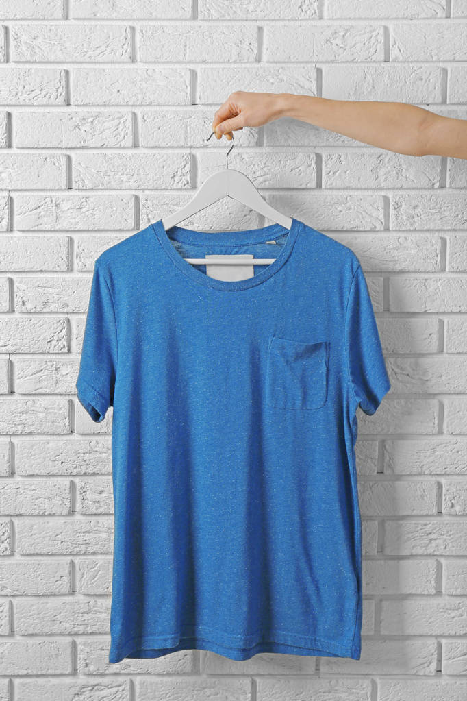 camiseta azul contra muro de ladrillo
 - Foto, imagen