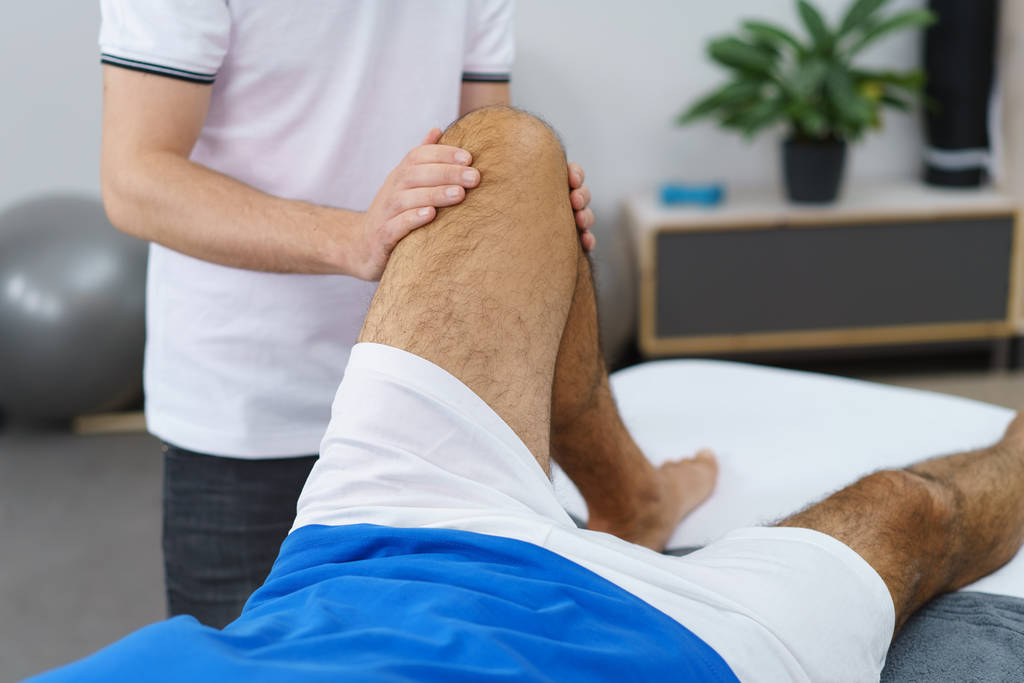 physiotherapist manipulates elderly mans leg - Photo, Image