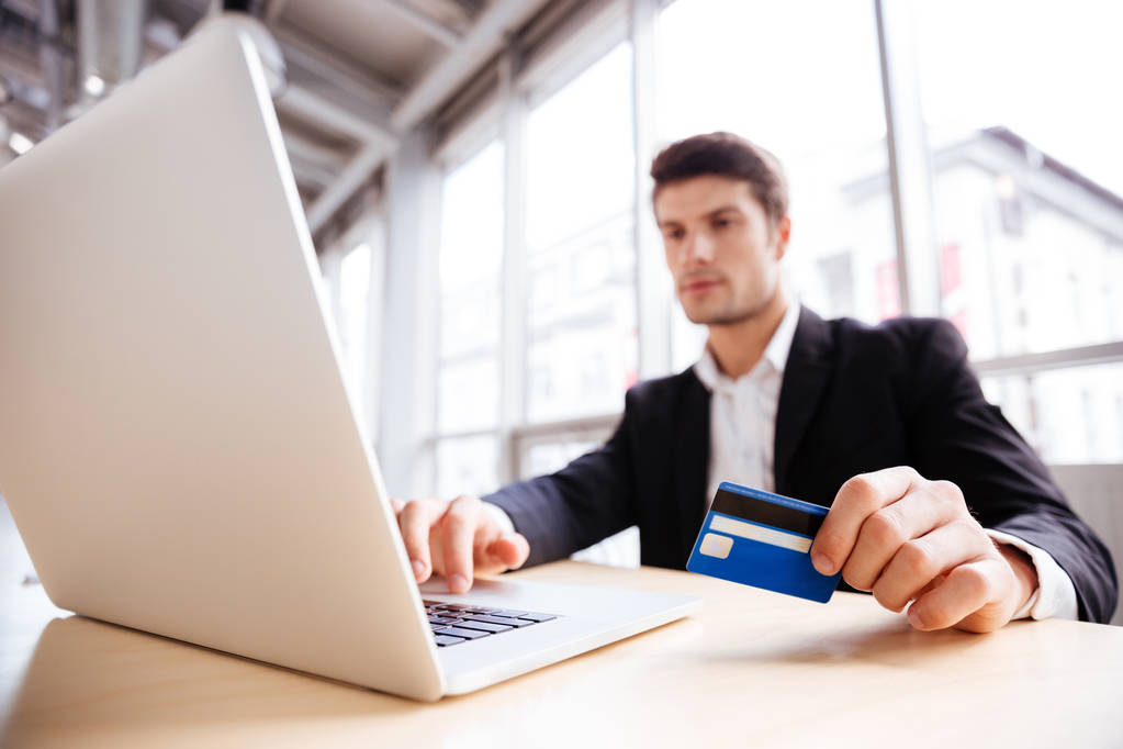 Επιχειρηματίας χρησιμοποιώντας φορητό υπολογιστή και την πιστωτική κάρτα στο γραφείο - Φωτογραφία, εικόνα