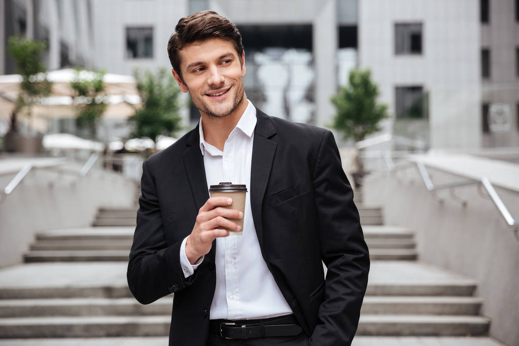 Heureux jeune homme d'affaires attrayant boire du café dans la ville
 - Photo, image
