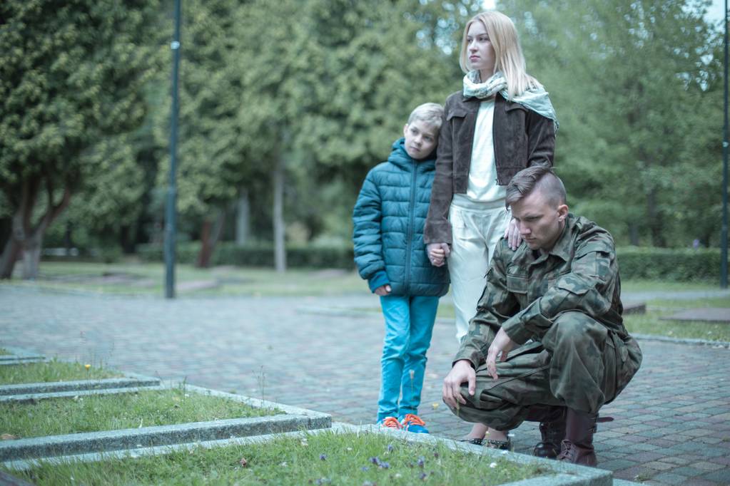 Солдат и его семья посещают могилу
 - Фото, изображение