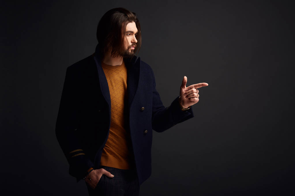 Hombre guapo y elegante con pelo largo en estudio oscuro con chaqueta azul
 - Foto, imagen