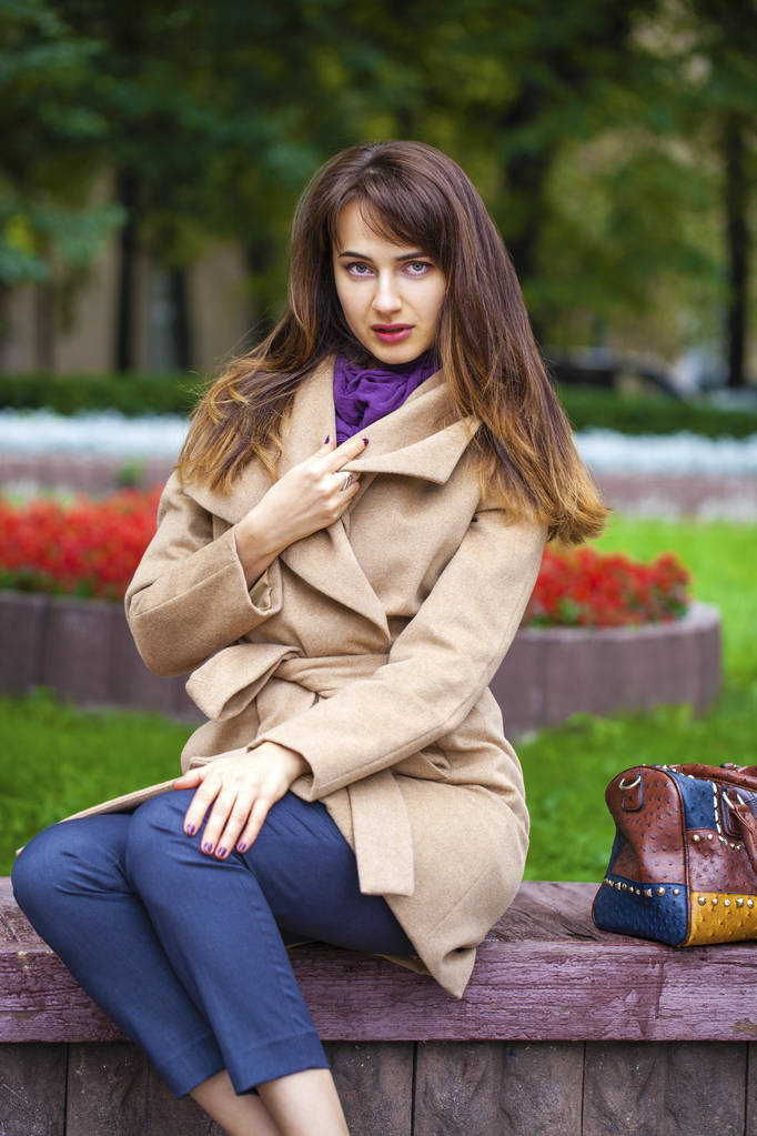 Πορτρέτο του μια νεαρή όμορφη γυναίκα σε μπεζ παλτό  - Φωτογραφία, εικόνα