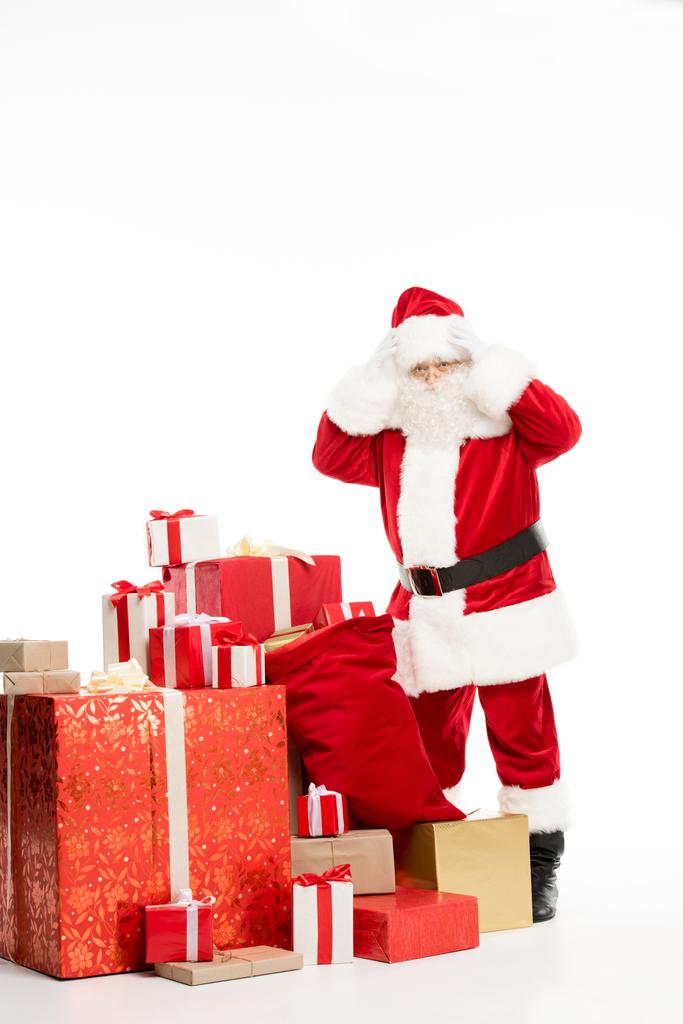 Shocked Santa Claus standing with Christmas gifts - Photo, Image