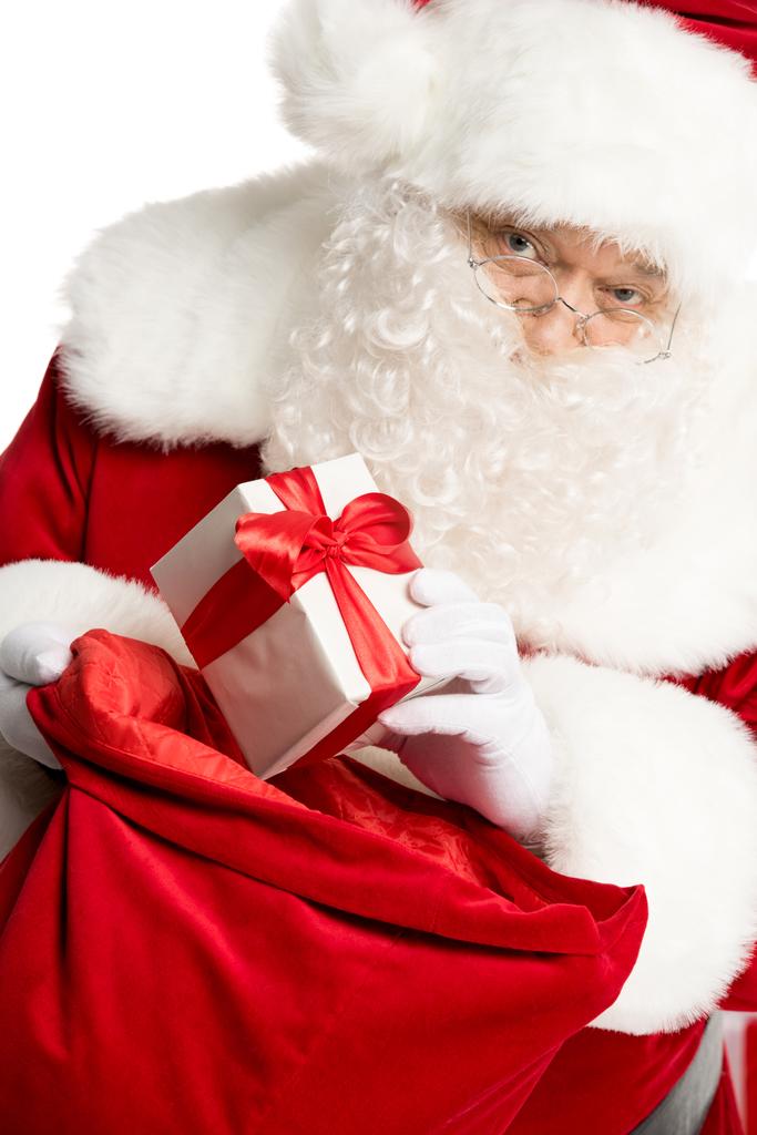 Weihnachtsmann holt Weihnachtsgeschenk aus Sack - Foto, Bild