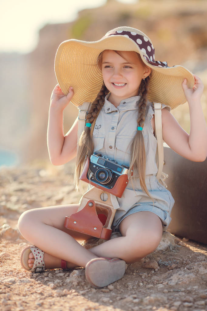 Νεαρή φωτογράφος με ένα μεγάλο καπέλο σε ένα βράχο - Φωτογραφία, εικόνα