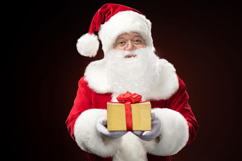Санта-Клаус с подарочной коробкой в руке
 - Фото, изображение