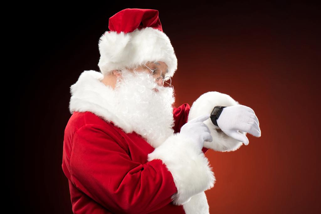Санта-Клаус указывает на умные часы
 - Фото, изображение