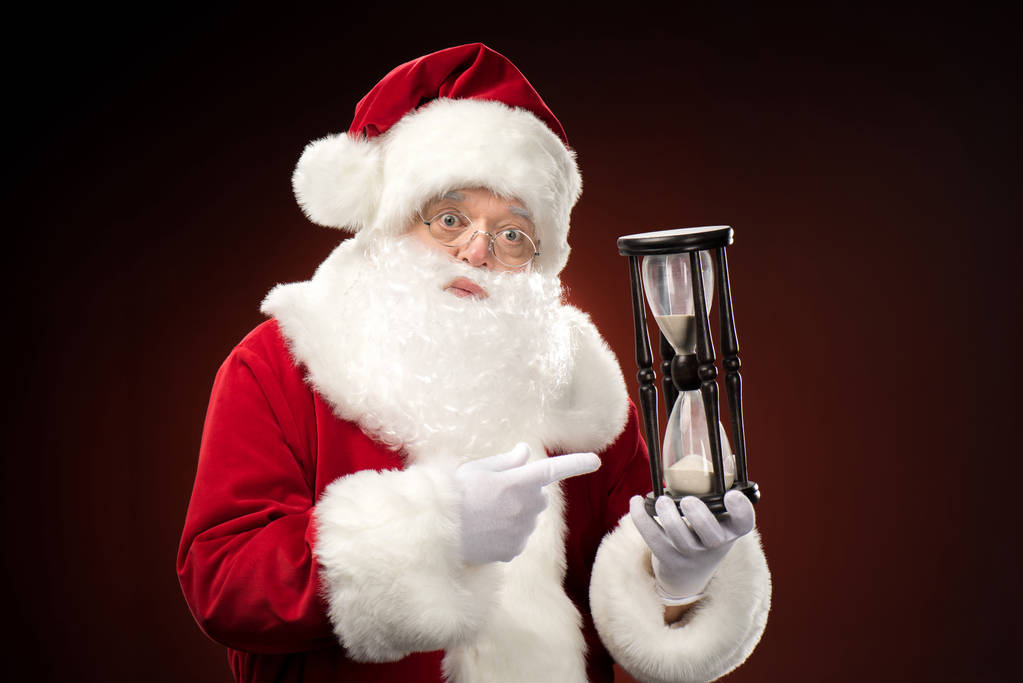 Santa Claus apuntando al reloj de arena
   - Foto, imagen