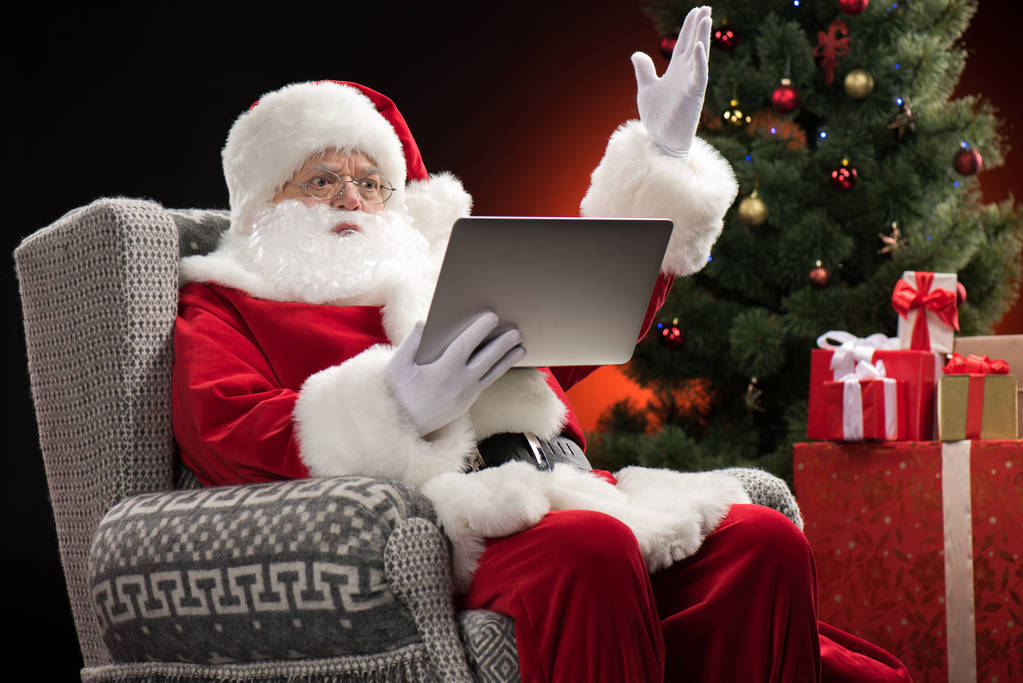 Санта-Клауса, використовуючи ноутбук і жестикулюючи - Фото, зображення