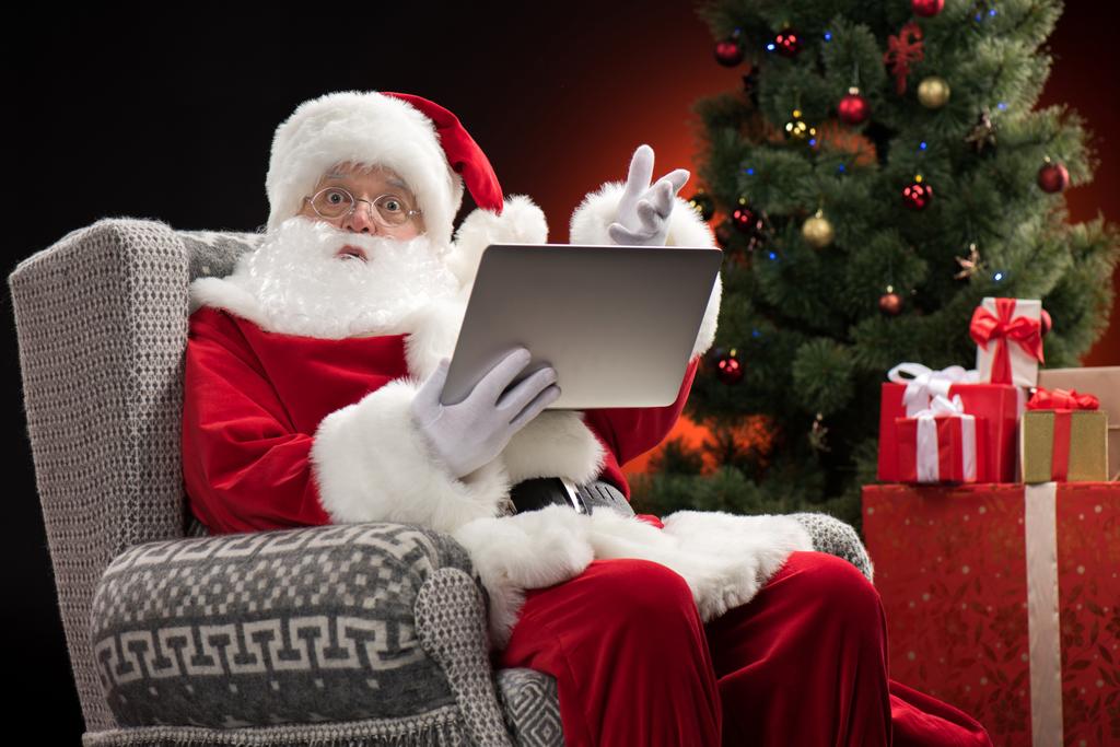 Babbo Natale utilizzando laptop e gesticolando
 - Foto, immagini