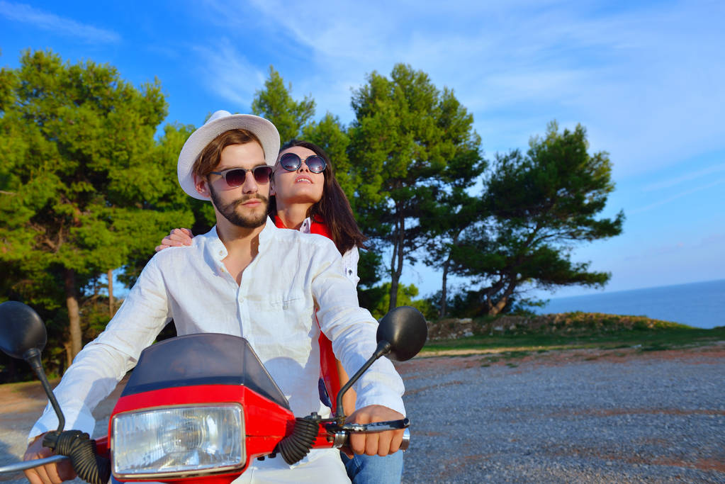 Beautiful young couple riding on a scooter - Photo, Image