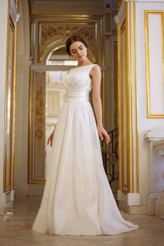 mooie jonge vrouw bruid in luxe trouwjurk in interieur - Foto, afbeelding