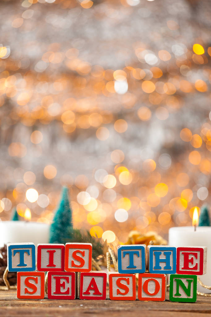 Tis a estação escrita com blocos de brinquedo no cartão de Natal vertical
 - Foto, Imagem