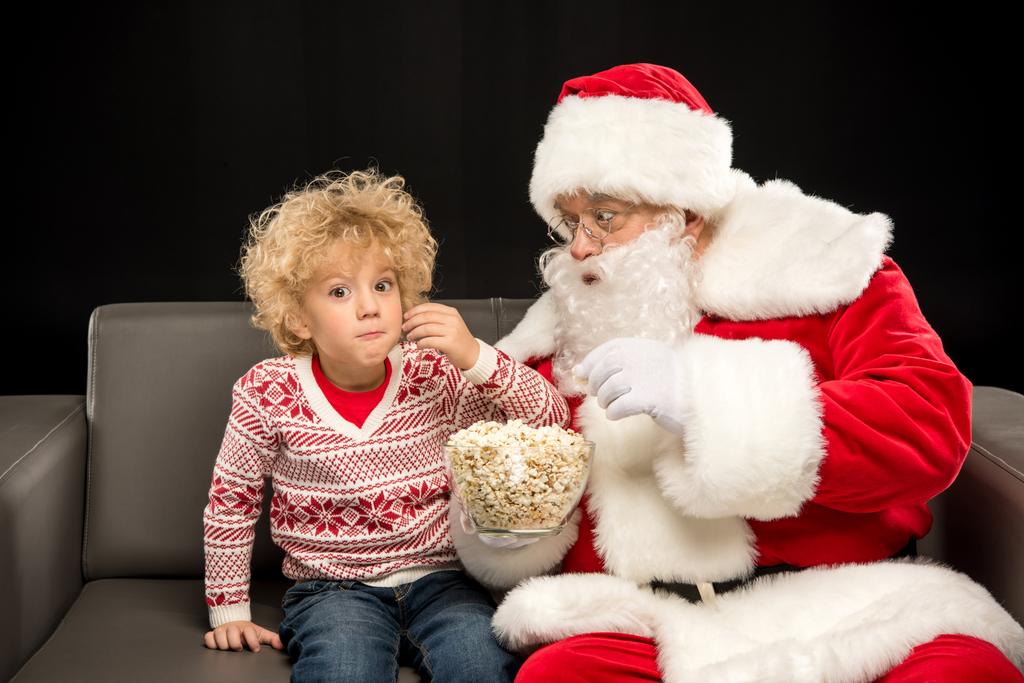 サンタ クロース子供でポップコーンを食べる   - 写真・画像