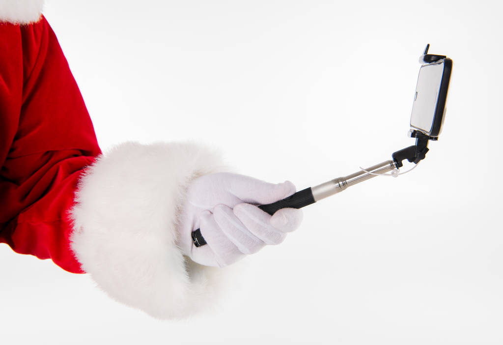 Papai Noel mão mostrando selfiestick
 - Foto, Imagem