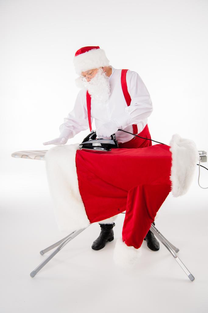 Santa Claus ironing coat - Photo, Image