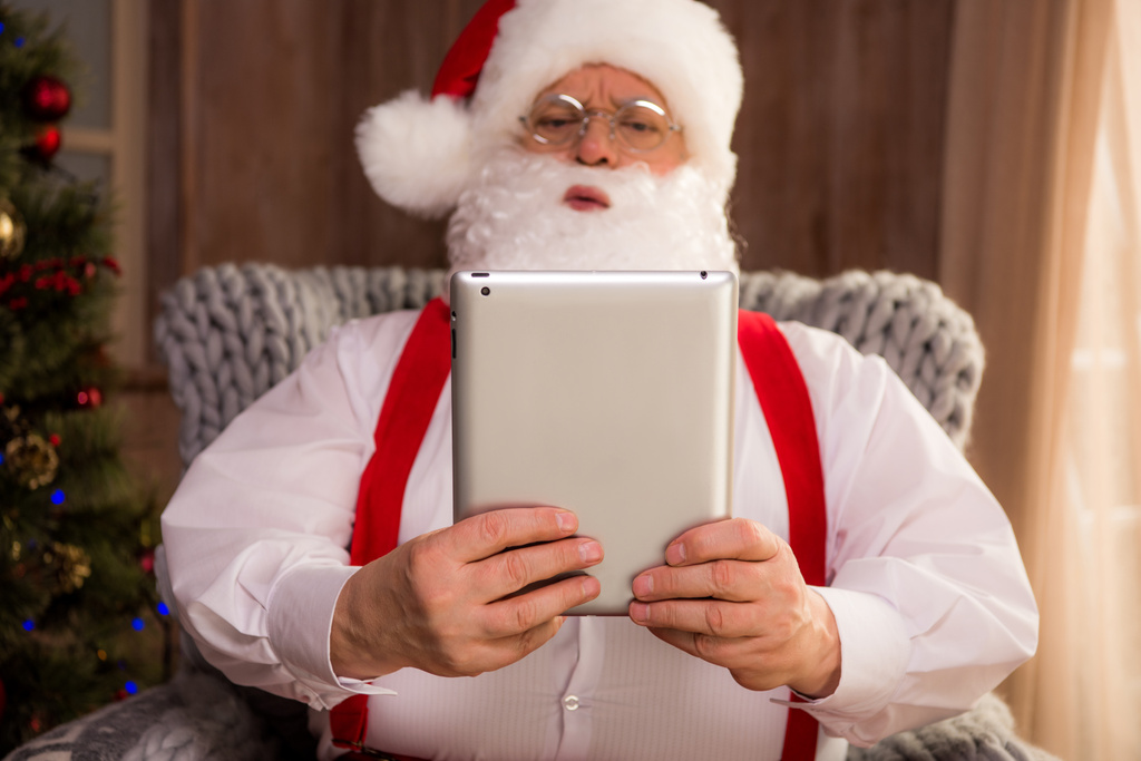 Santa claus met behulp van digitale Tablet PC - Foto, afbeelding