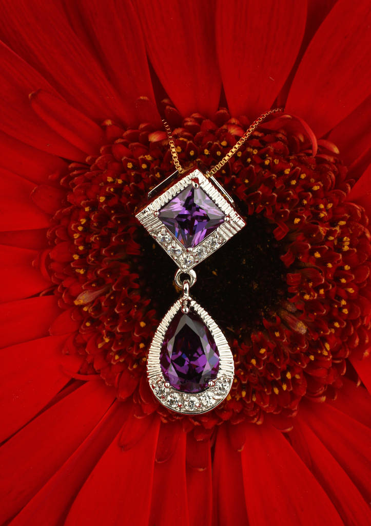 Κρεμαστό κόσμημα κοσμήματα με διαμάντια και σπινελλίων σε φόντο λουλούδι - Φωτογραφία, εικόνα