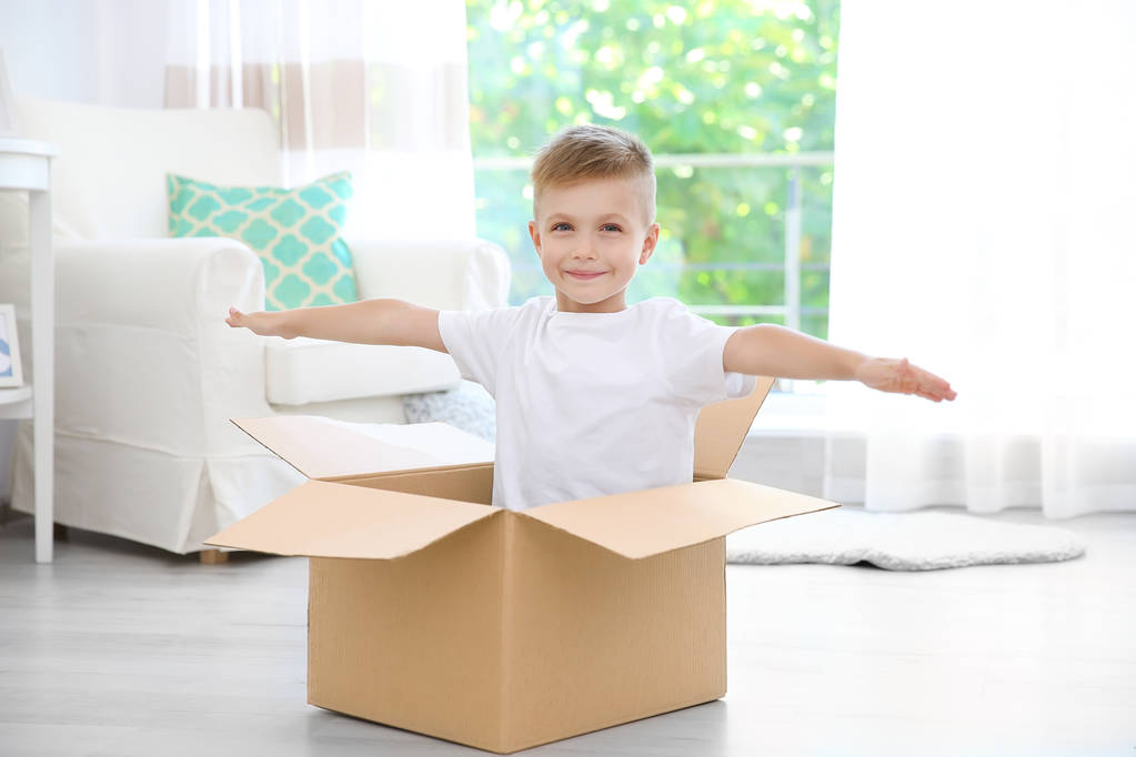 Niño jugando con caja de cartón
  - Foto, Imagen