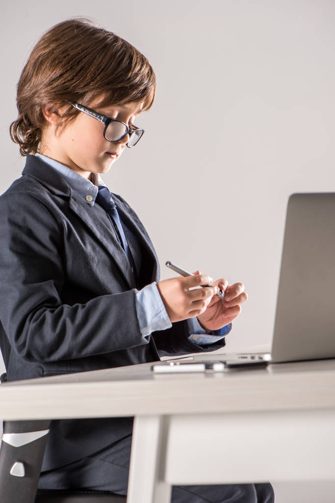 Schulkind im Business-Anzug mit Stift in der Hand - Foto, Bild