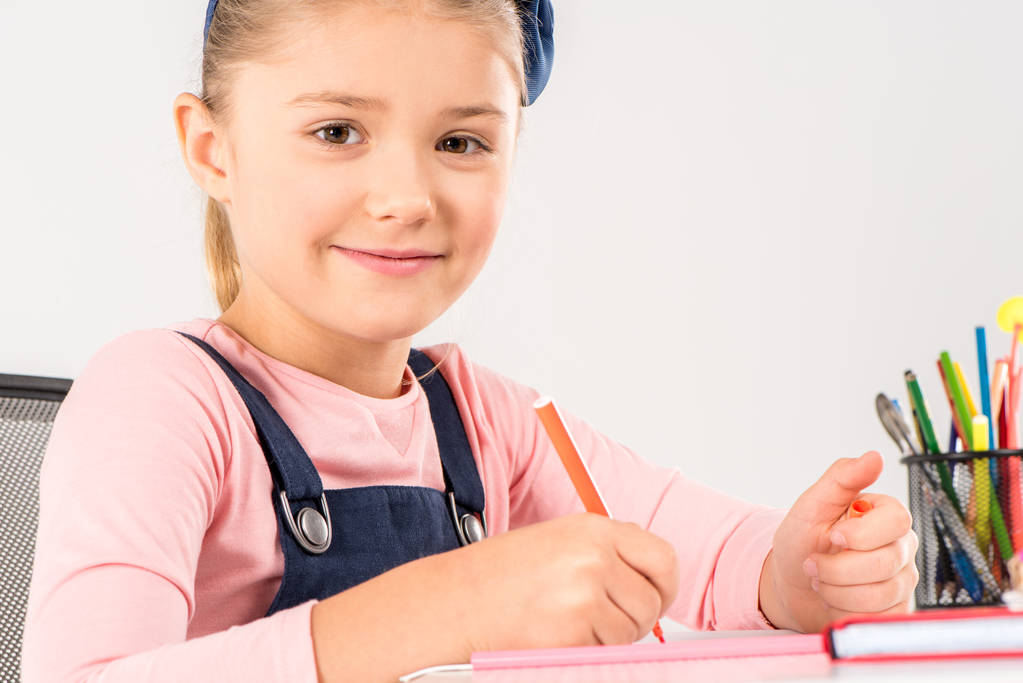 Усміхнена школярка робить домашнє завдання
 - Фото, зображення