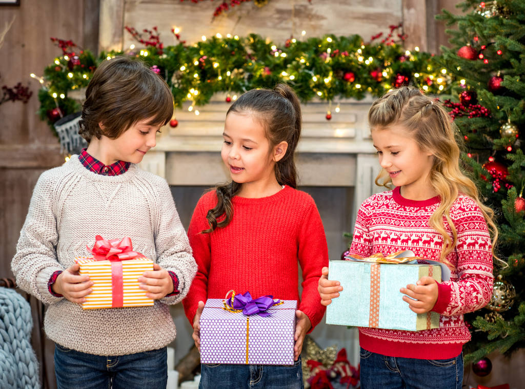 Niños felices sosteniendo cajas de regalo
  - Foto, imagen