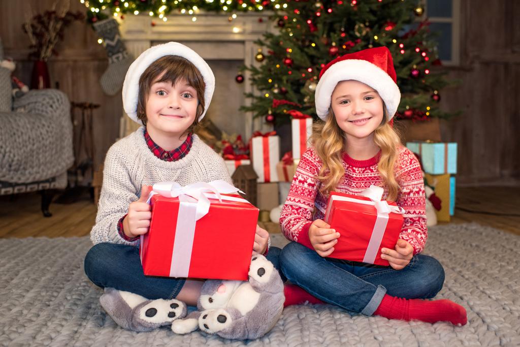 niños en sombreros de Santa con regalos de Navidad
 - Foto, imagen