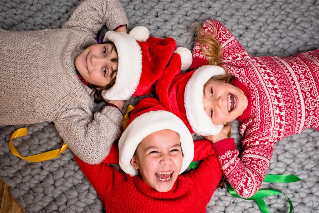 дети в шляпах Санта лежит в кругу
 - Фото, изображение