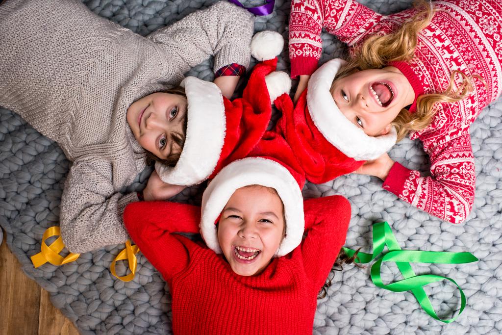 Noel Baba şapkaları daire içinde yalan çocuklarda - Fotoğraf, Görsel
