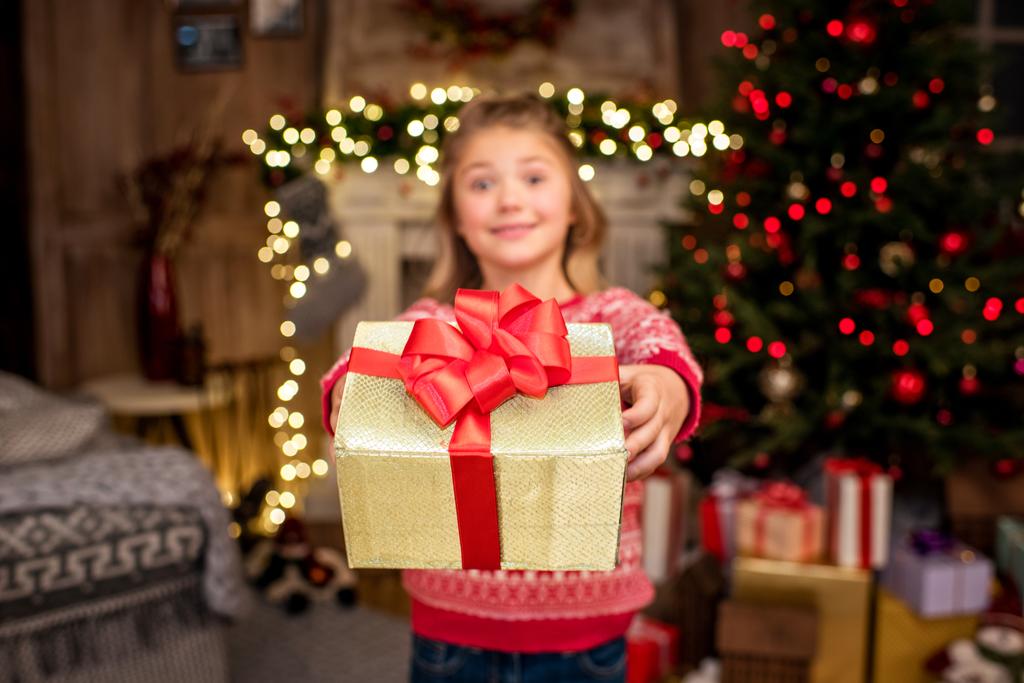 Niño feliz mostrando caja de regalo
   - Foto, imagen