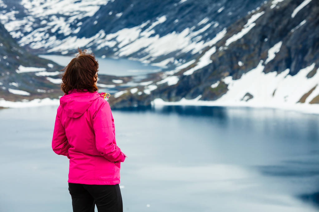 ノルウェーのジュプヴァトネット湖に立つ観光客の女性 - 写真・画像
