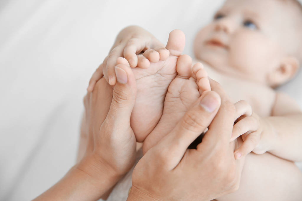 Madre sosteniendo los pies de su bebé de cerca
 - Foto, Imagen