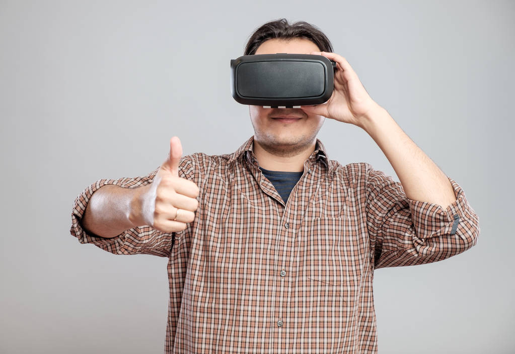 Felice giovane uomo utilizzando auricolare realtà virtuale
 - Foto, immagini