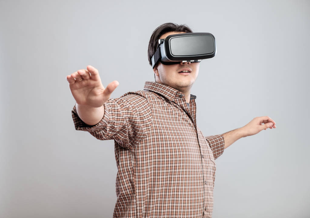 Felice giovane uomo utilizzando auricolare realtà virtuale
 - Foto, immagini