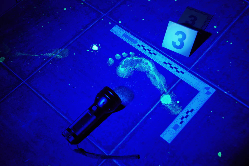 Foot print visible under UV black light on place of crime - Photo, Image