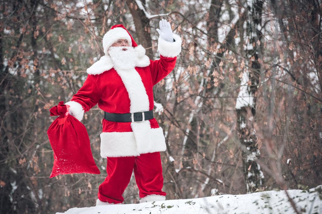 Papai Noel andando com saco cheio de presentes
 - Foto, Imagem