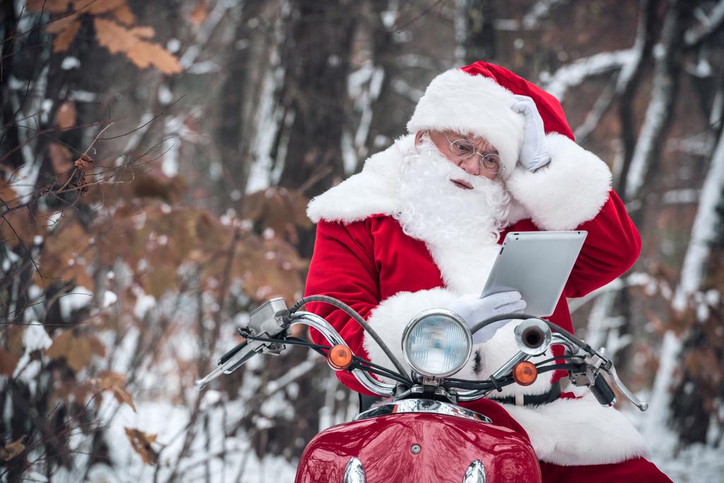 Санта-Клауса на скутер використання планшетного  - Фото, зображення