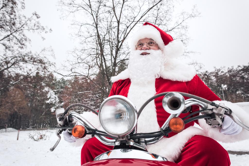 Papai Noel montando scooter vermelho
 - Foto, Imagem