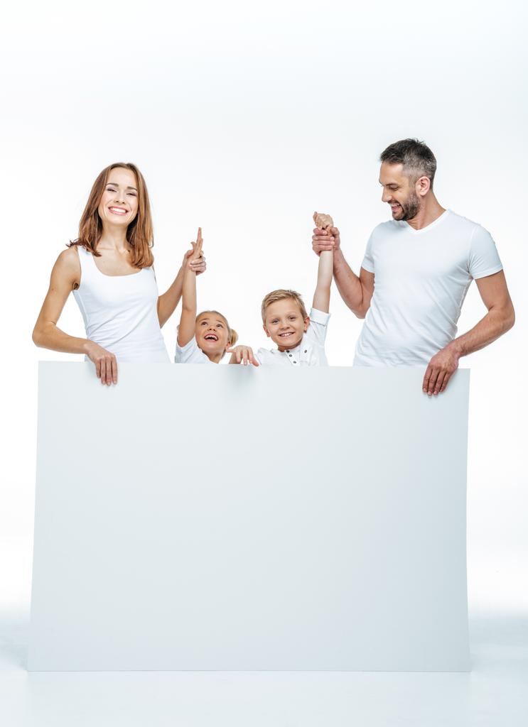Familia sonriente sosteniendo tarjeta en blanco
 - Foto, imagen