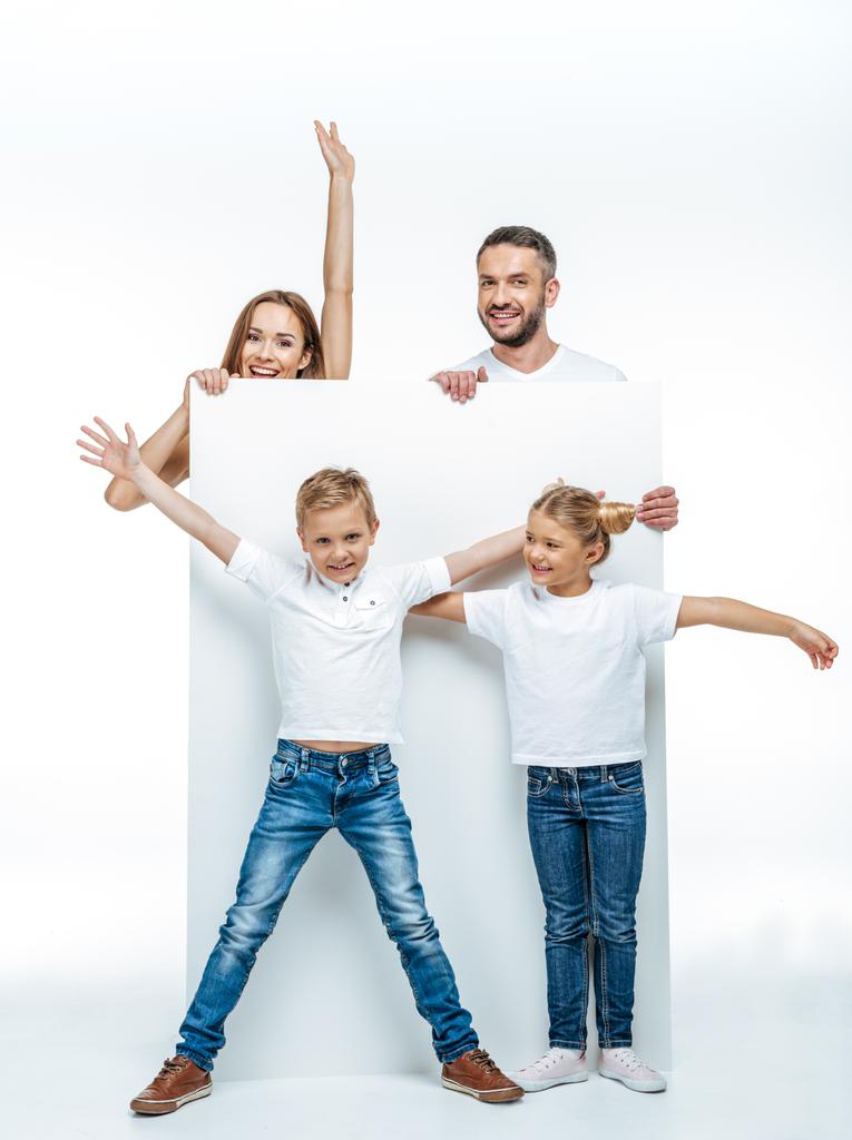 Familia alegre sosteniendo la tarjeta en blanco
 - Foto, imagen