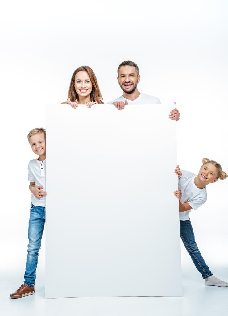 Família sorridente segurando cartão em branco
 - Foto, Imagem