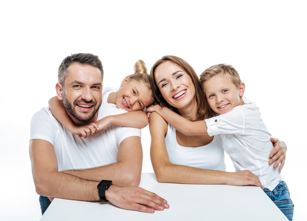 Lächelnde Familie in weißen T-Shirts umarmt  - Foto, Bild